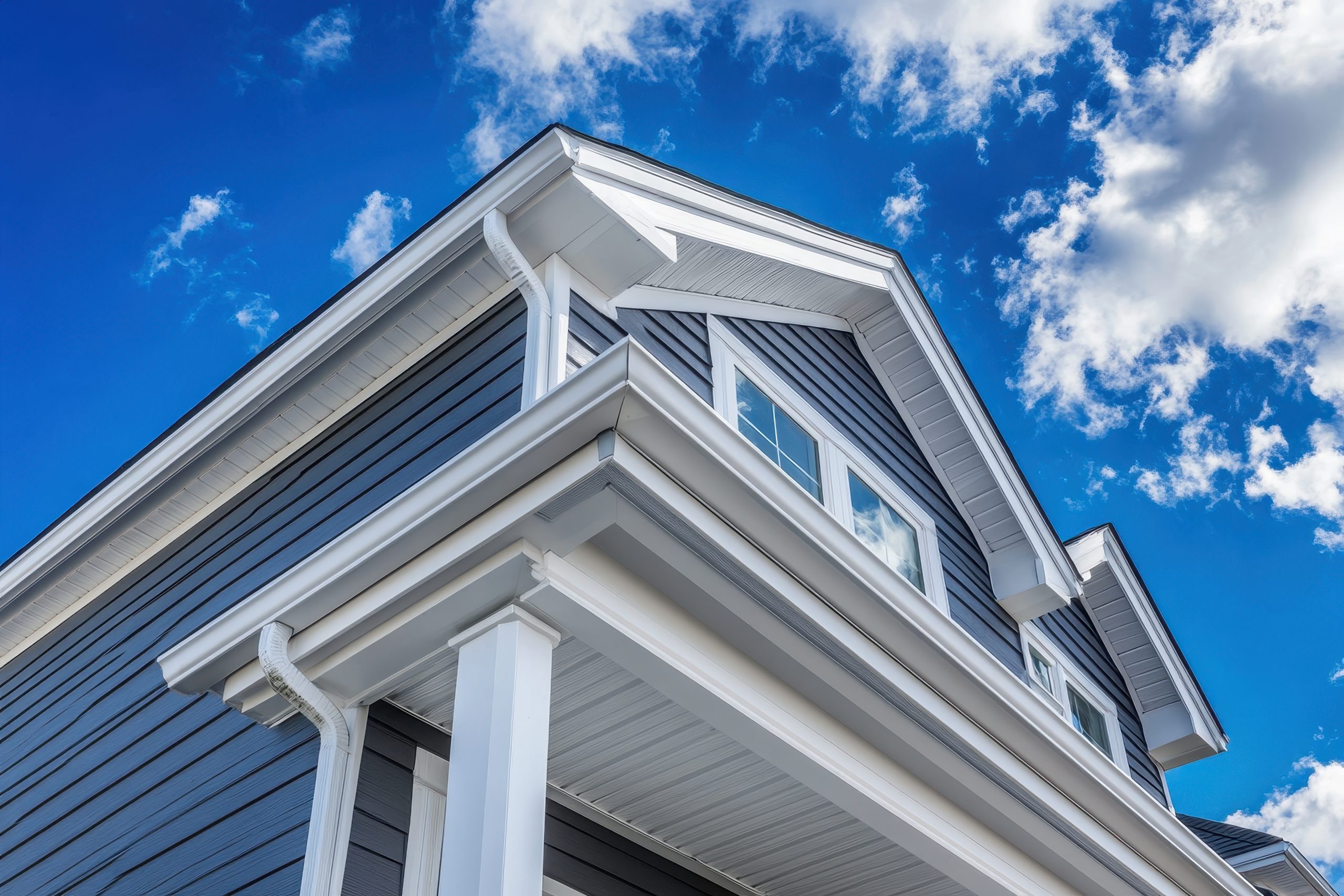 Colonial Style White Gutter System Ventilated Soffit And Gray Vinyl Siding In An Upscale American Neighborhood